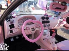 the interior of a car is decorated with pink and white accessories, including steering wheel