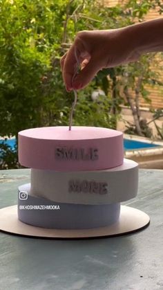 someone is lighting the candle on top of a cake that says, smile moms