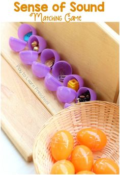 a basket filled with orange eggs sitting on top of a wooden table next to a toy train