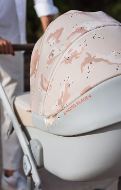 a baby stroller with a pink and white cover on it's back seat