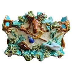 an animal figurine is sitting on top of a decorative plate with blue accents