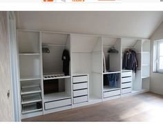 an empty room with white shelves and drawers