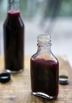 a bottle filled with liquid sitting on top of a wooden table next to another bottle