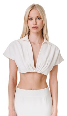 A collar crop top with pleating detail at bust, fully lined, and elastic hem. This item is pre-order starting May 3rd- May 24th and is expected to ship the first week of June. Any expedited requests please email support@odette-odile.com. Material: Self; 75% Nylon, 25% Polyester, Lining; 100% Silk Fit: Model is 5'9, wearing size XS. Styled with the Renata Maxi Skirt. Care Instructions: Dry Clean Only Do Not Bleach Do Not Tumble Dry Cool Steam Only Chic Fitted Cropped Shirt With Collar, Elegant Fitted Cropped Shirt, Fitted Cropped Padded Top, Chic Fitted White Cropped Shirt, Chic White Fitted Cropped Shirt, White Fitted Cropped Shirt Chic Style, Summer Fitted Crop Top With Foldover, Summer V-neck Padded Crop Top, Fitted Foldover Crop Top For Summer