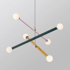 a chandelier with five lights hanging from it's sides and three different colored rods