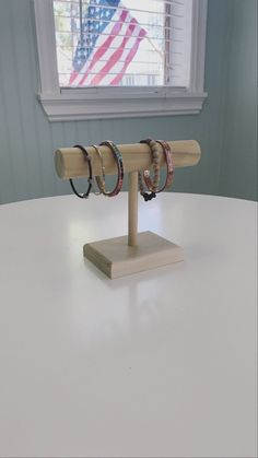 three pairs of rings on a wooden stand in front of a window with an american flag