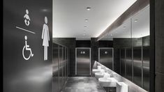 a public restroom with urinals, sinks and toilet paper dispensers