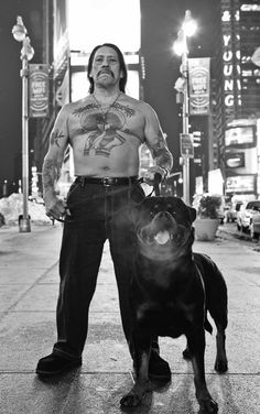 a man standing next to a dog on a city street