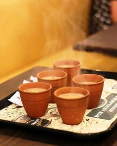 four cups on a tray with steam rising from them