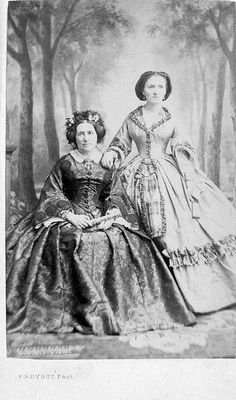 an old photo of two women in dresses