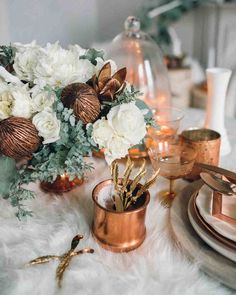 the table is set with gold and white flowers