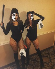 two women dressed in costumes holding baseball bats