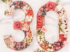 the number 50 is made up of flowers and fruits on a white marble table top