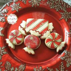 some cookies are on a red plate with snowflakes and candy canes around them