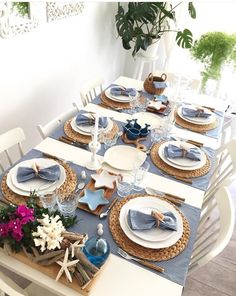 the table is set with blue and white plates, napkins, and place settings