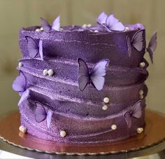 there is a purple cake with butterflies on it