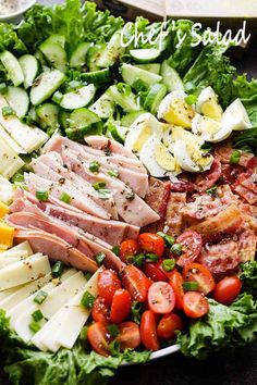 a salad with ham, cheese, tomatoes and cucumbers in it on a plate