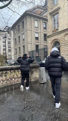 two people walking down the street in winter