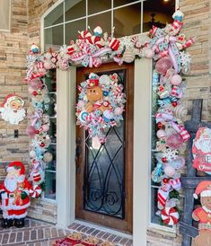 a christmas wreath on the front door of a house with santa clause decorations around it