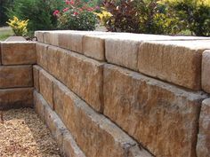 a stone wall in the middle of a garden