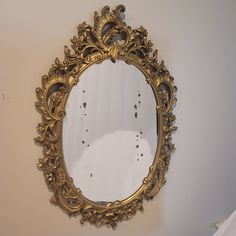 an ornate gold mirror hanging on the wall