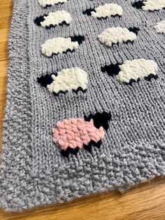 a knitted blanket with sheep on it