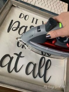 a person is using an iron on top of a sign