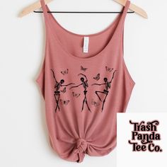 Dancing ballet skeletons with butterflies loose flattering tank top - slouchy tank top - ballerina skeletons - gothic design - unique tops  *All of my tees are have a "vintage vibe" (I hope that's the look you're going for!) and the designs may not be as bright as pictured, due to the triblend and 50/50 cotton poly fabrics of the high quality T-shirts used to give the vintage feel.   PRODUCTION AND SHIPPING  * Processing is 4-7 business days. All of my tees are made to order (WITH LOVE!) If you experience any issue with your package, please contact your local USPS facility. * Tracking is provided by me and all orders are shipped out of Erie, PA.  * Estimated "receive by" dates are estimates only. Once the item is dropped off at the USPS facility, I no longer have control of your package. T Stretch Sleeveless Top With Skull Print, Sleeveless Stretch Top With Skull Print, Summer Skull Print Tank Top, Summer Tank Top With Skull Print, Sleeveless Skull Print Top For Summer, Sleeveless Summer Top With Skull Print, Fairy Grunge Sleeveless Tops, Unique Top, Gothic Design