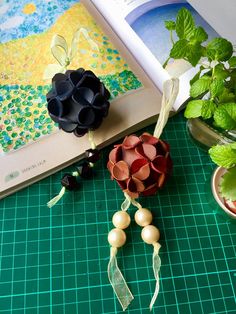 an open book sitting on top of a green table next to flowers and other items