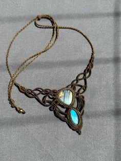 the necklace is adorned with an intricate design and blue glass cabochons on it