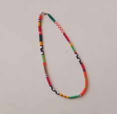 a multicolored beaded necklace on a white surface