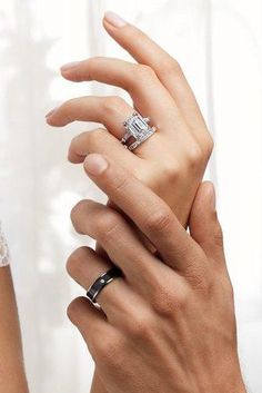 a man and woman holding each other's hands with their wedding rings on them