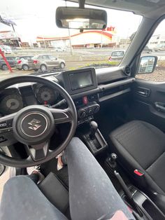 the interior of a vehicle with its dashboard and dash lights on, in a parking lot