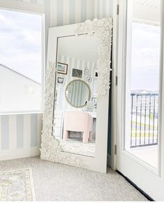 a mirror sitting on top of a white door next to a window