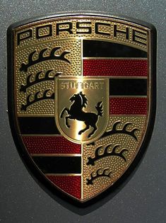 an emblem on the side of a car that is shiny gold and has red stripes