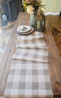 a wooden table topped with plates and flowers