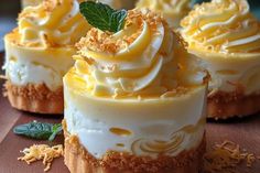 four desserts with white frosting and green leaves