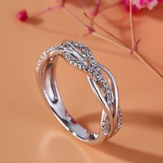 Bring the bling with this shimmering band. Expertly crafted in sterling silver, this clever style features gracefully intertwined ribbons to create a sparkling intertwined design. This unique band is a glittering gift of truest love.Carat Weight: 0.46 ctStone Size: 1 mmStone Type: Jeulia® StoneNumber of Stones: 46 Stone Color: Diamond WhiteStone Shape: RoundWeight: 4.57 gWidth: 5.64 mmHeight: 2.42 mmThickness: 2.86 mmMaterial: 925 SilverPlating Color: Silver Jeulia Jewelry, Infinity Wedding Band, Promise Ring Band, Infinity Engagement Ring, Unique Bands, Band Engagement Ring, Womens Wedding Bands, Anniversary Bands, Rings For Her