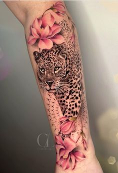 a woman's arm with a leopard and flowers on it