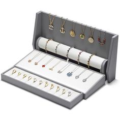 an open jewelry box with various necklaces and bracelets in the bottom section, on a white background