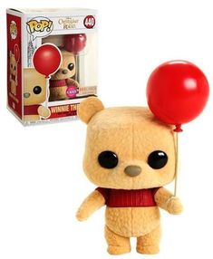 a teddy bear with a red balloon attached to it's head, next to a pop vinyl box