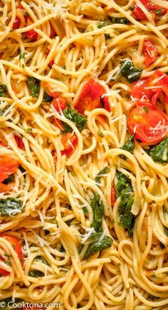 pasta with tomatoes, spinach and cheese in a pan