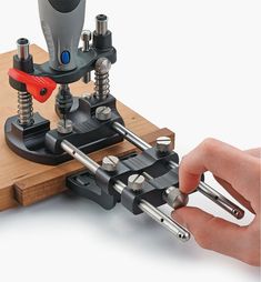 a person is working on a machine with two screwdrivers attached to the base