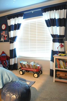 a child's bedroom with blue walls and striped curtains