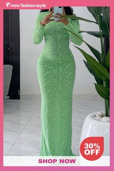 a woman in a green dress taking a selfie with her cell phone while standing next to a plant