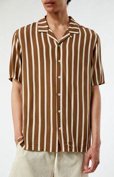 Step up your style game with the Brown Striped Camp Shirt from PacSun. This shirt features a collared neckline, short sleeves, a standard fit, button closures, and a striped pattern. With a lightweight feel, it's the perfect addition to elevate your rotation and keep you looking fresh and on-trend.


	Collared neckline
	Short sleeves
	Standard fit
	Button closures
	Striped
	100% Rayon
	Machine washable
	Model is wearing size medium
	Model Measurements: 6'2” Height, 28" Waist, 32” Inseam Camp Shirt, Camping Shirt, Personal Marketing, Shirt Price, Model Measurements, Pacsun, Step Up, Cool Style, Short Sleeves