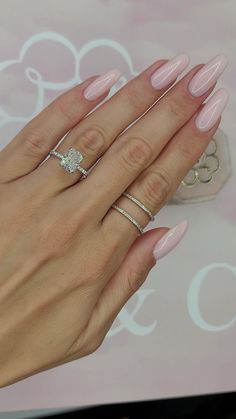 a woman's hand with pink manicured nails and ring