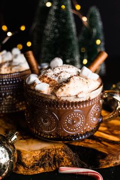 two mugs filled with hot chocolate and marshmallows on a wooden table