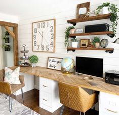 a desk with two chairs and a large clock on the wall above it in a home office