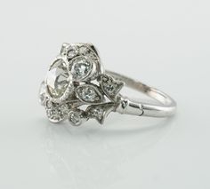 Art Deco Ring, Floral Ring, Flower Ring, Natural Diamonds, April Birthstone & Platinum Ring, 1930s Ring, Estate Ring, Engagement Ring or Wedding Ring, Elegant Ring. This vintage Ring circa the 1930s is finely crafted in luxurious Platinum and set with genuine diamonds. The center Old Mine cut natural diamond is 1.20 carat of VS2 clarity and J color. Two smaller bezel set old mine cut diamonds total .40 carat. And more round cut gems total .40 carat of SI2 clarity and J color. The grand total Diamond Cluster Ring For Wedding In Art Deco Style, Diamond Art Deco Cluster Ring For Wedding, Art Deco Platinum Cluster Ring For Wedding, Vintage Platinum Cluster Diamond Ring, Estate Platinum Diamond Ring With Diamond Cut, Heirloom Style Platinum Cluster Diamond Ring, Heirloom Platinum Cluster Diamond Ring, Estate Platinum Diamond Ring With Brilliant Cut, Estate Style Platinum Diamond Ring With Brilliant Cut